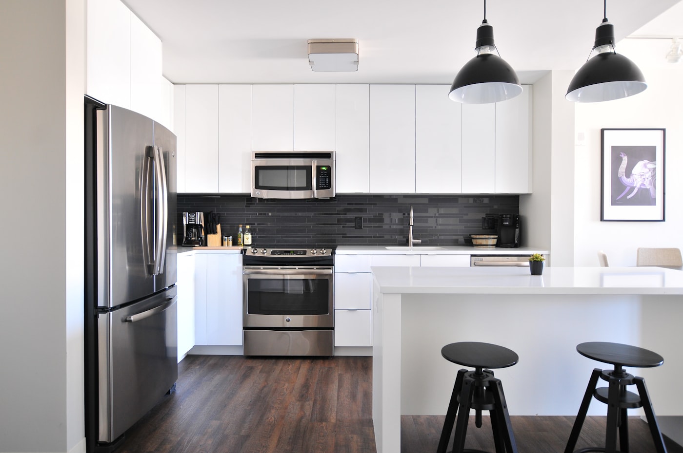 Handleless white slab kitchen with a dark tile backsplash