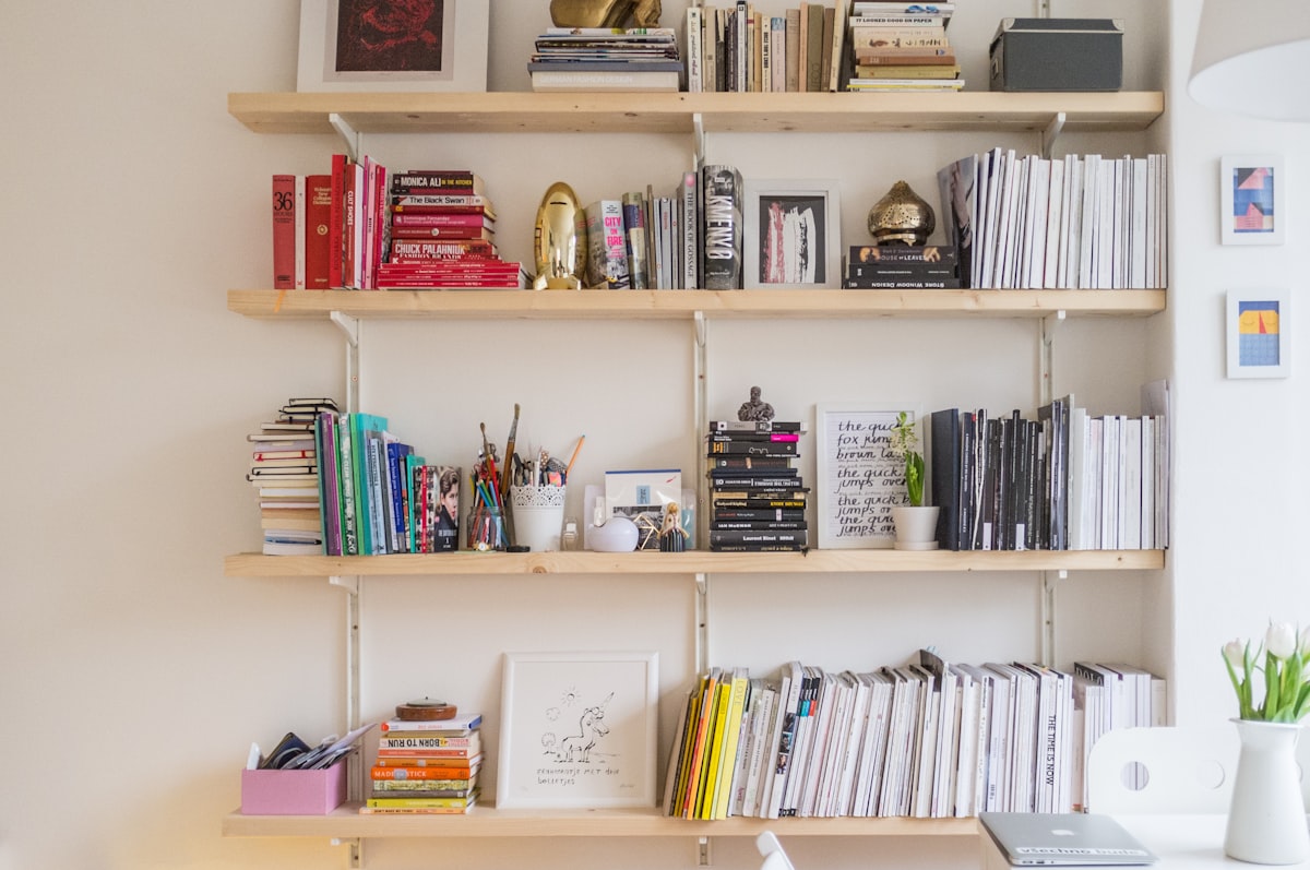 Small solid wood bedside table with two open shelves holding books