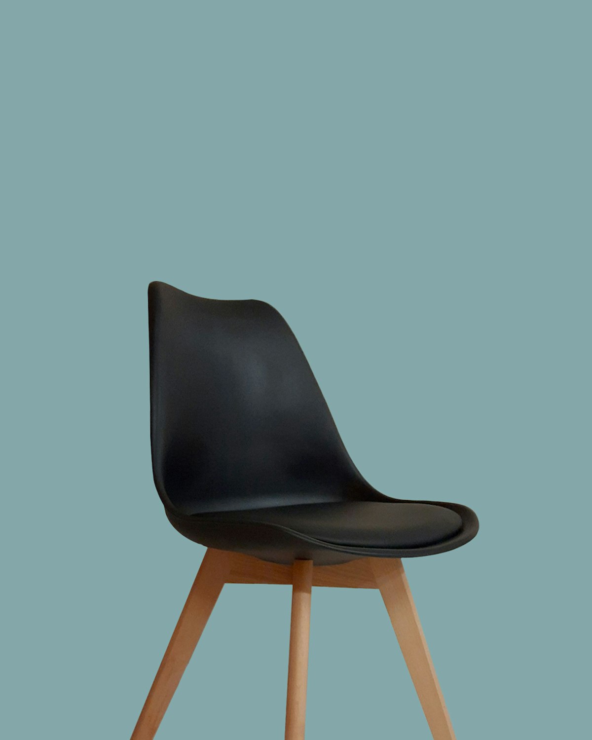 Black moulded dining chair on tapered wooden legs