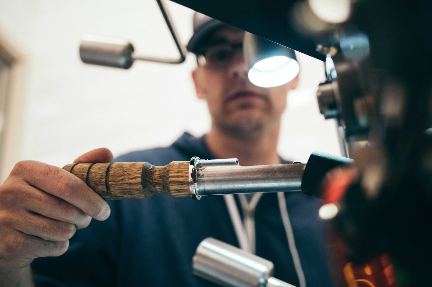Carpenter at the bench fitting a turned wooden handle into a machine